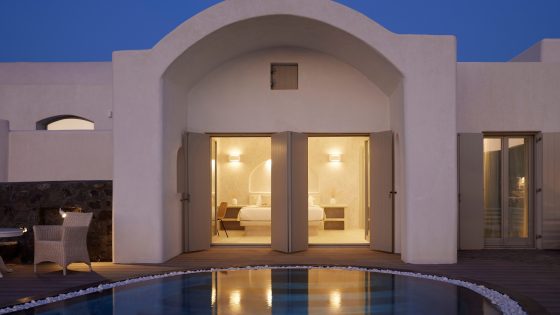 evening view across swimming pool to guestrooms at Danae Suites Santorini