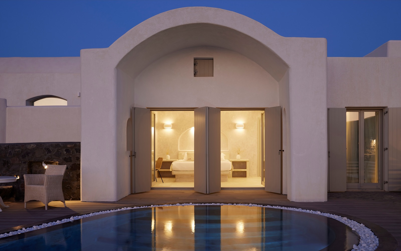 evening view across swimming pool to guestrooms at Danae Suites Santorini