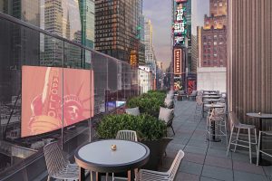 reflections from Times Square billboards at outdoor terrace and seating at the New York Marriott Marquis