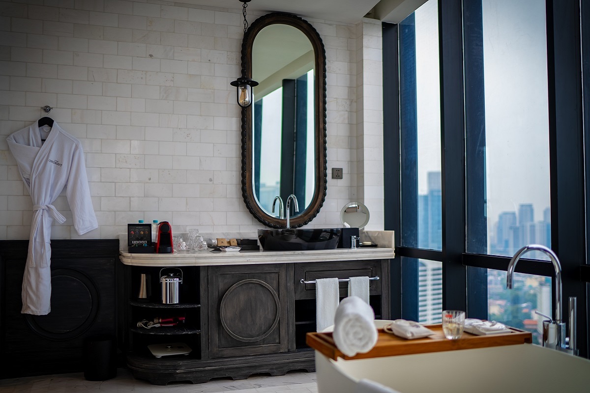 Bathroom in white and wood in The Orient Jakarta by Barceló Hotel Group