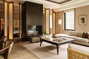 fireplace and seating in neutral tones in guestroom at Aman New York