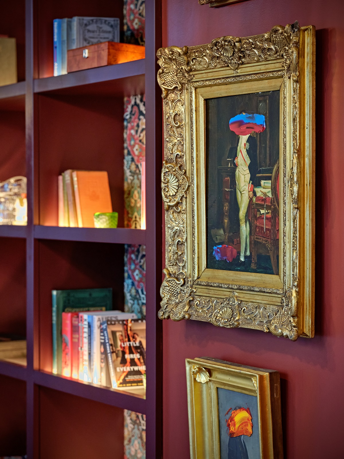 gold gilt frames on red wall with upcycled oil paintings in The Other House