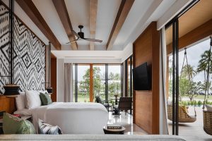 interior blanco y madera en la suite en el entorno tropical de Khao Lak Resort & Spa