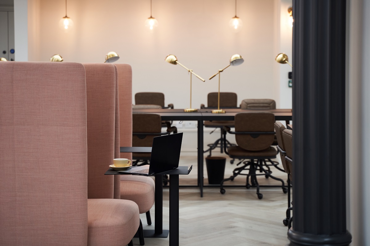 pink banquettes and wooden desks in co-working space in Dandi Wembley