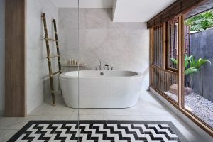 freestanding bath with bamboo towel ladder opening onto courtyard