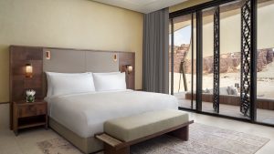guestroom at Banyan Tree Alula with framed view of desert decorated in natural tones of the location