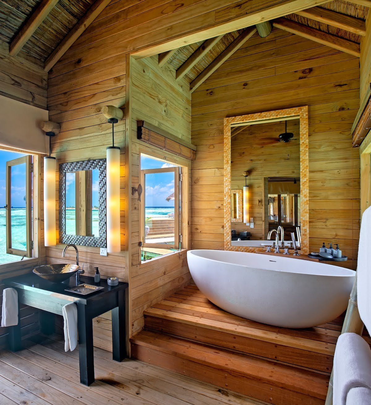 A wooden bathroom with freestanding bath overlooking the Indian Ocean