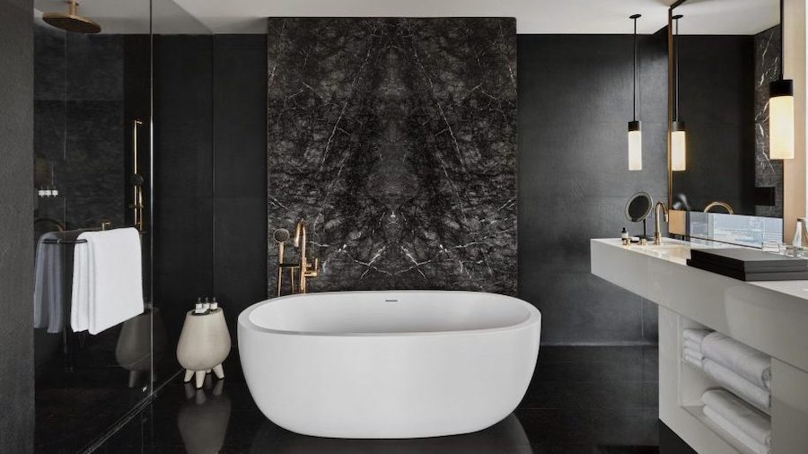 A white bath in black marble bathroom