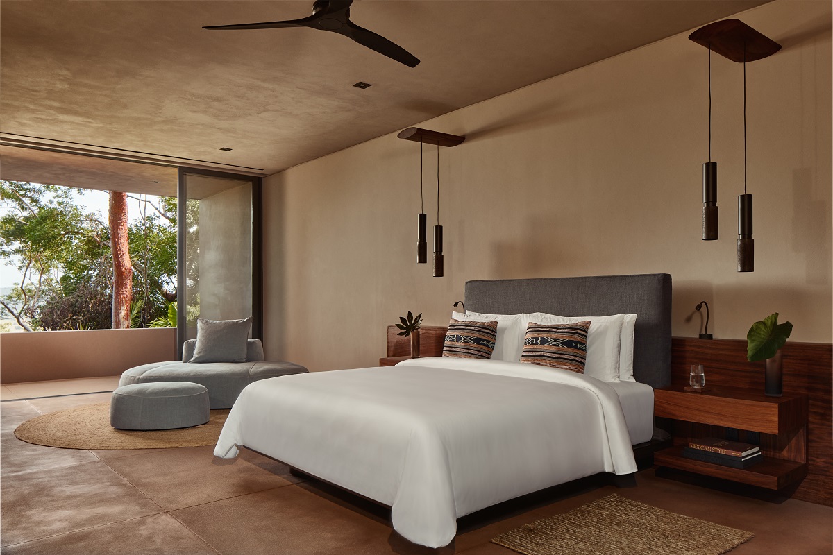 bedroom in One&Only Mandarina decorated in natural colours and textures with white linen and ceiling fan