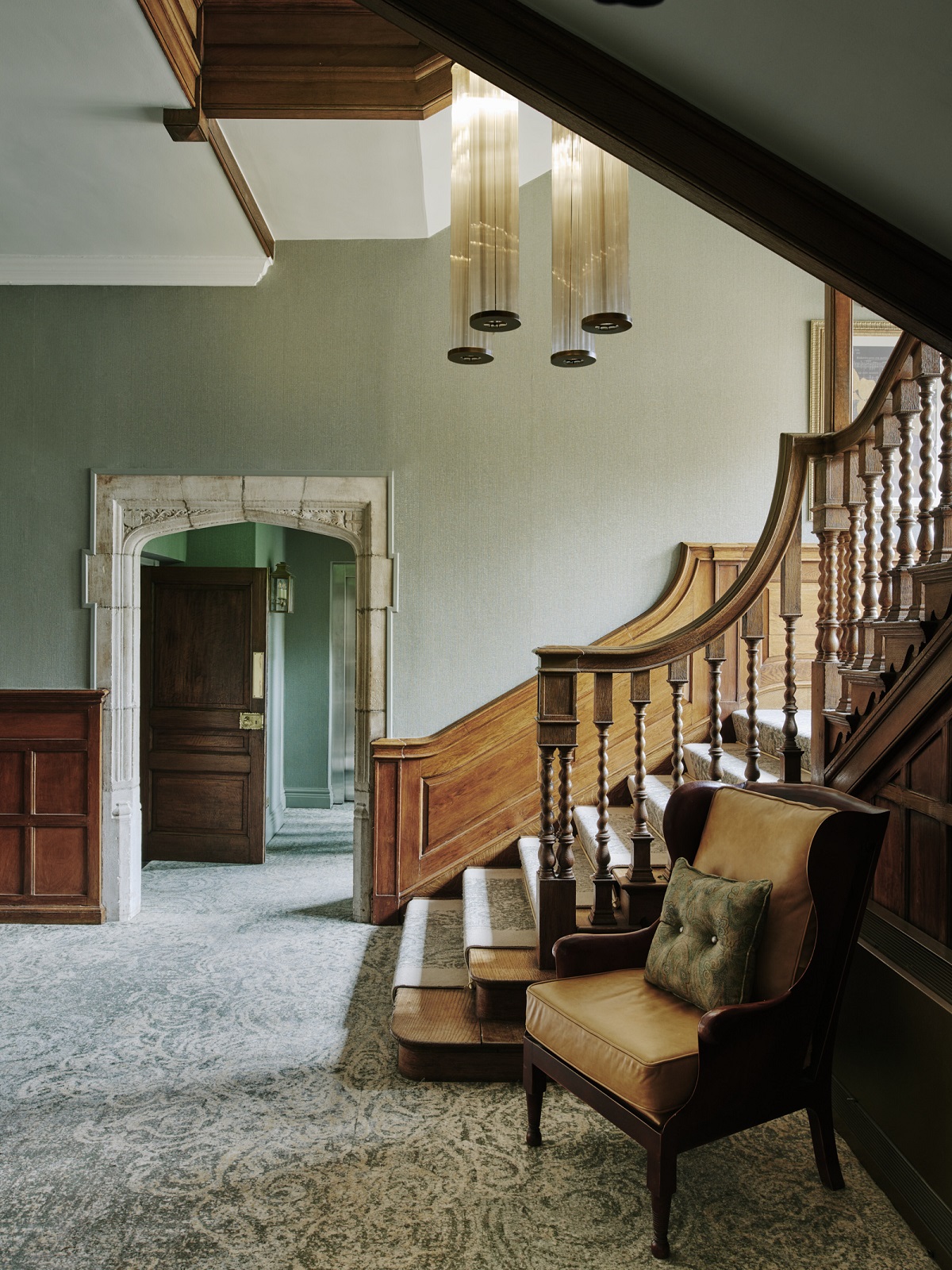 period wooden staircase and bespoke fluted light in hall at Horwood House