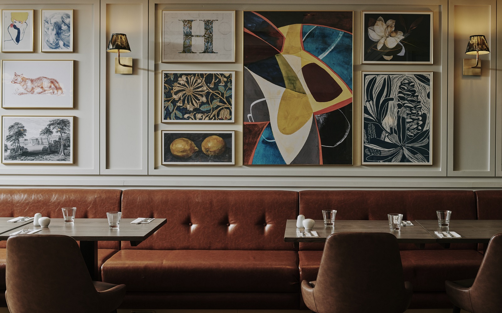 eclectic mix of art on the wall of restaurant in Horwood House hotel behind leather banquette seating