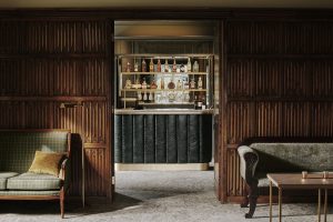 original period wood panelled walls with view through to leather fronted bar designed by Ica Studio for Horwood House Hotel