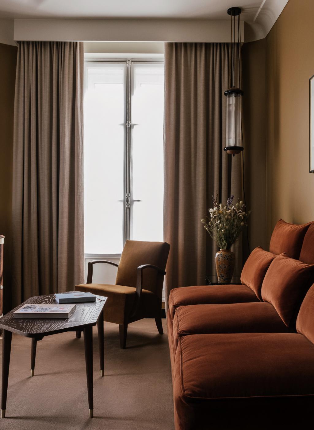 brown velvet couch and vintage chairs in Hôtel Rochechouart in Paris