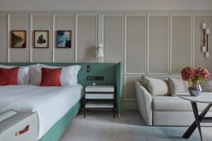 guestroom by Jestico + While in Mandarin Oriental Luzern in a palette of green, coral and wood alongside contemporary furniture design