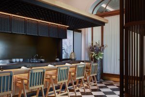 chequerboard black and white floor in F&B space in Mandarin Oriental Luzern with wooden chairs and bar detail
