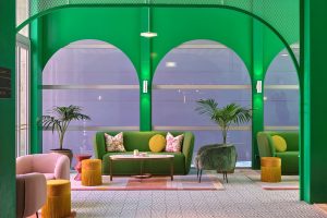 green walls and arched windows in the Parlour at Naumi Wellington with yellow and terracotta accents in cushions