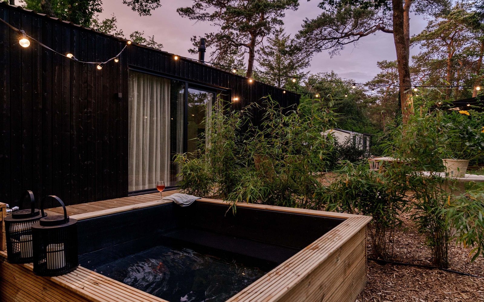 external view of Mori tinyhouse in the forest with fairylights and plungepool