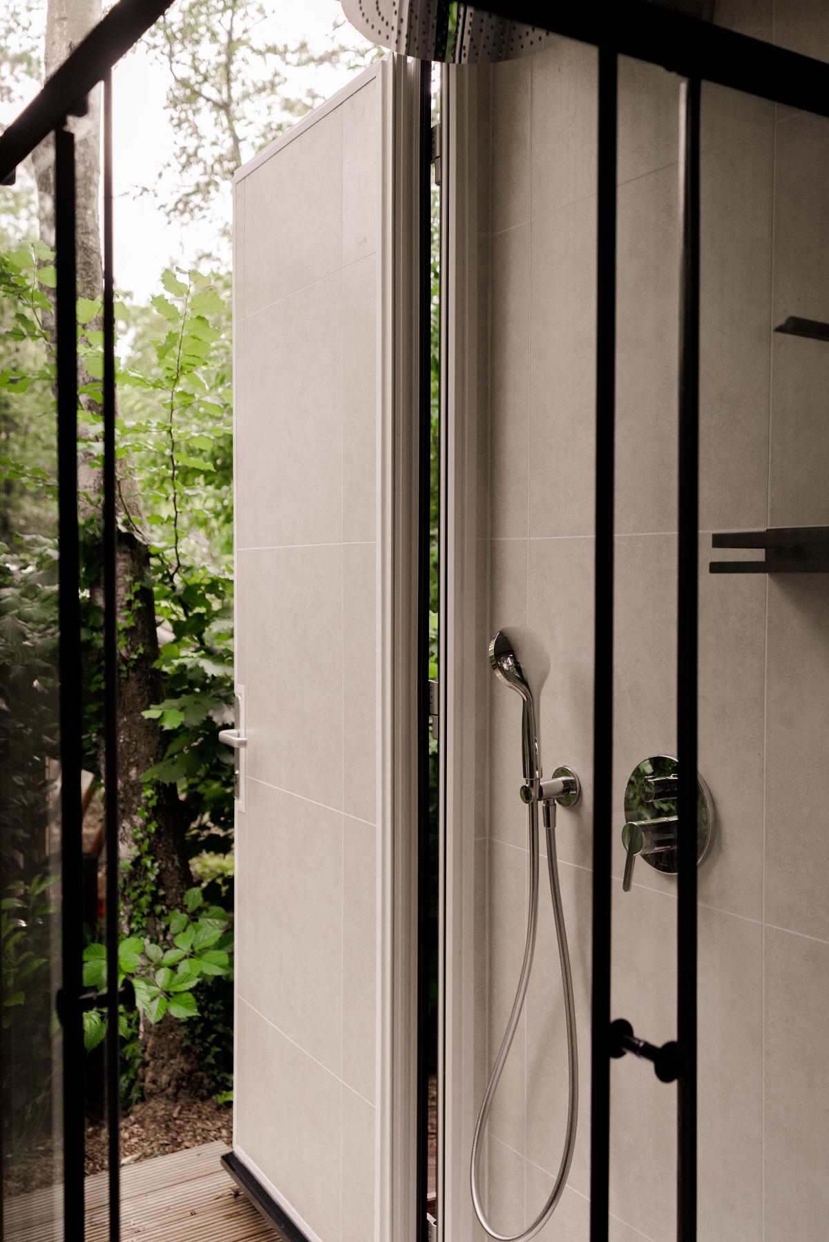 the indoor shower connects to outdoor shower with Duravit fittings in matt black inMori tinyhouse