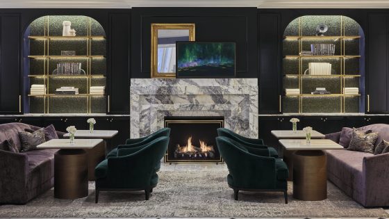 fireplace and comfortable peacock blue seating in the Peacock Lounge at Waldorf Astoria Chicago