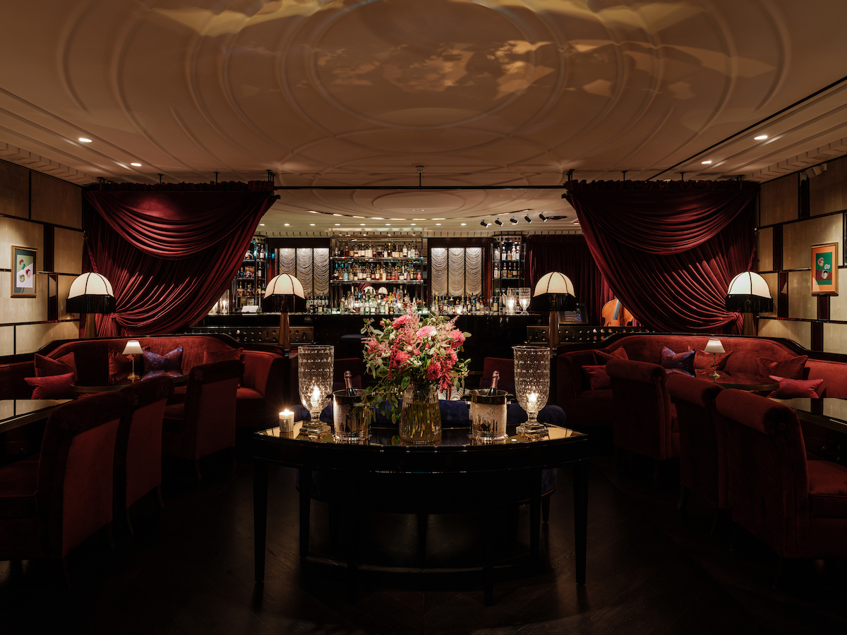 A wide angle of a Velvet-draped cocktail bar