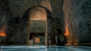natural aged brick surfces and atmospheric lighting define the pools in Aire London SpaA