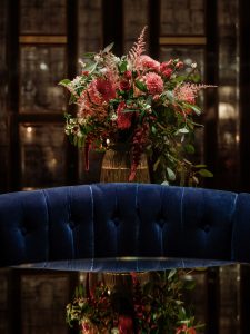 Blue sofa with bouquet of flowers in London cocktail bar