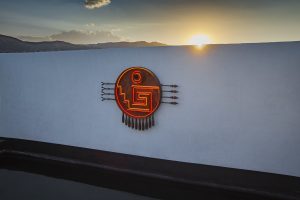 swimming pool and neon logo on the roof at sunset at Hotel Sin Nombre