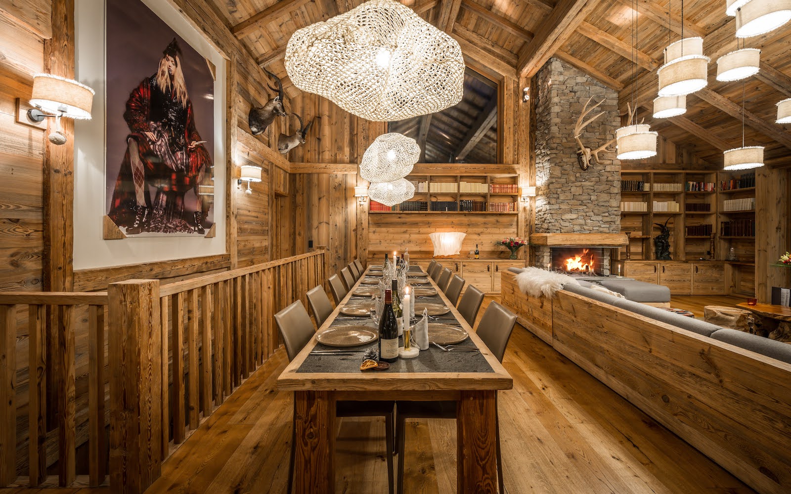 Modern alpine interiors inside Chalet Inoka, with large contemoporary artwork on wall and cloud-like chandeliers from ceiling