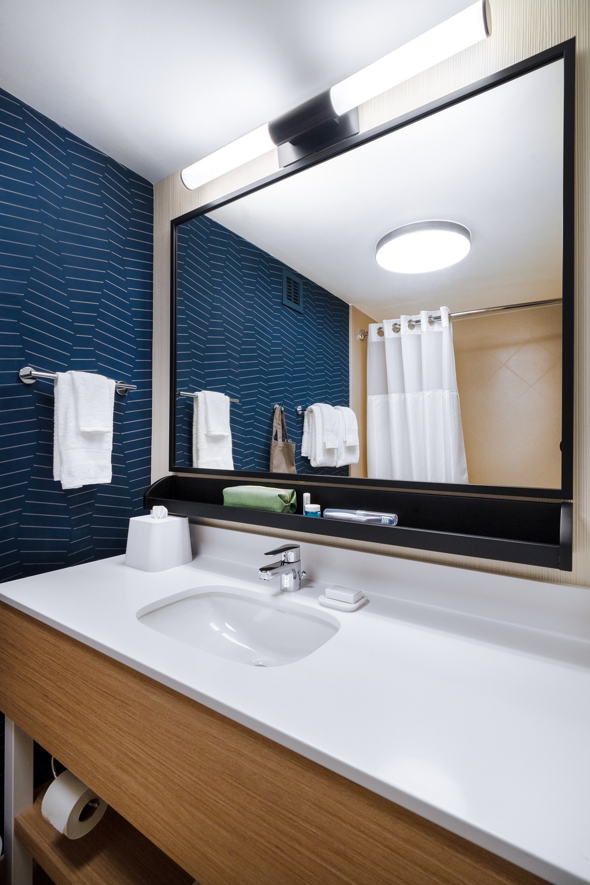 Spark by Hilton bathroom with blue tiles and wood and white surfaces