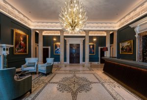 blue walls and mosaic floors in The Langley with chandelier by Dernier & Hamlyn