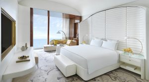 white curved headboard and furniture in guestroom at Fairmont Doha