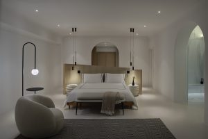 white bedroom interior with curved furniture, lighting and ensuite in the private villa