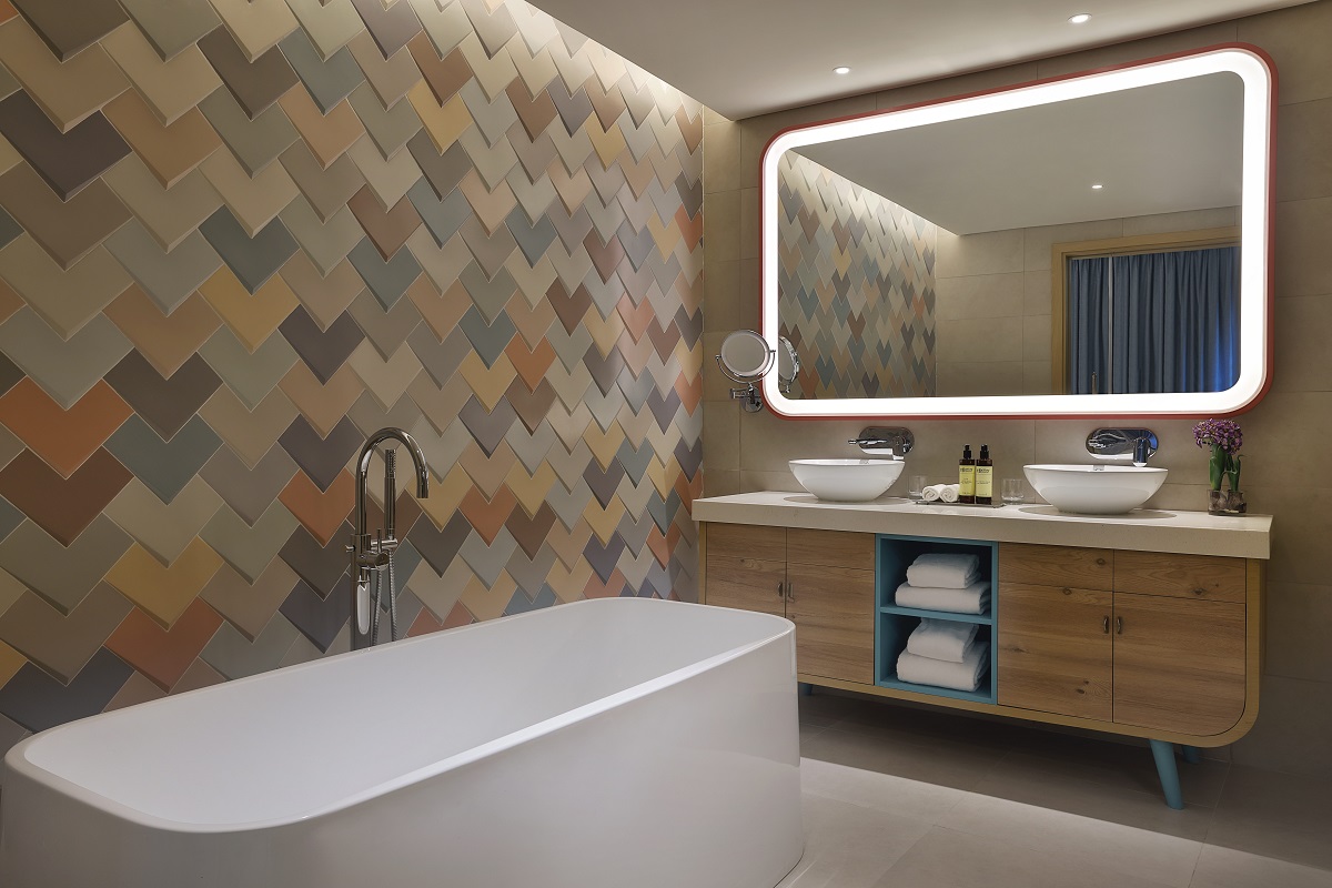 mosaic tiles, wooden furniture and free standing bath in the bathroom at NH Collection Dubai The Palm