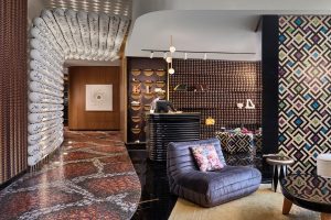 snakeskin tiles, seating and a beaded wall designed by Stickman Tribe in the lobby at W Dubai