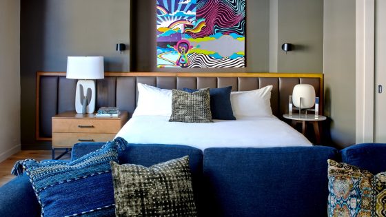 colourful painting and blue sofa in the guestroom at Hotel Ziggy in Los Angeles