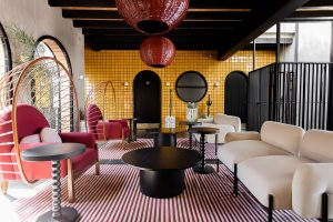 red striped carpet, yellow tiled wall and black architectural details on the terrace at Casa Hoyos