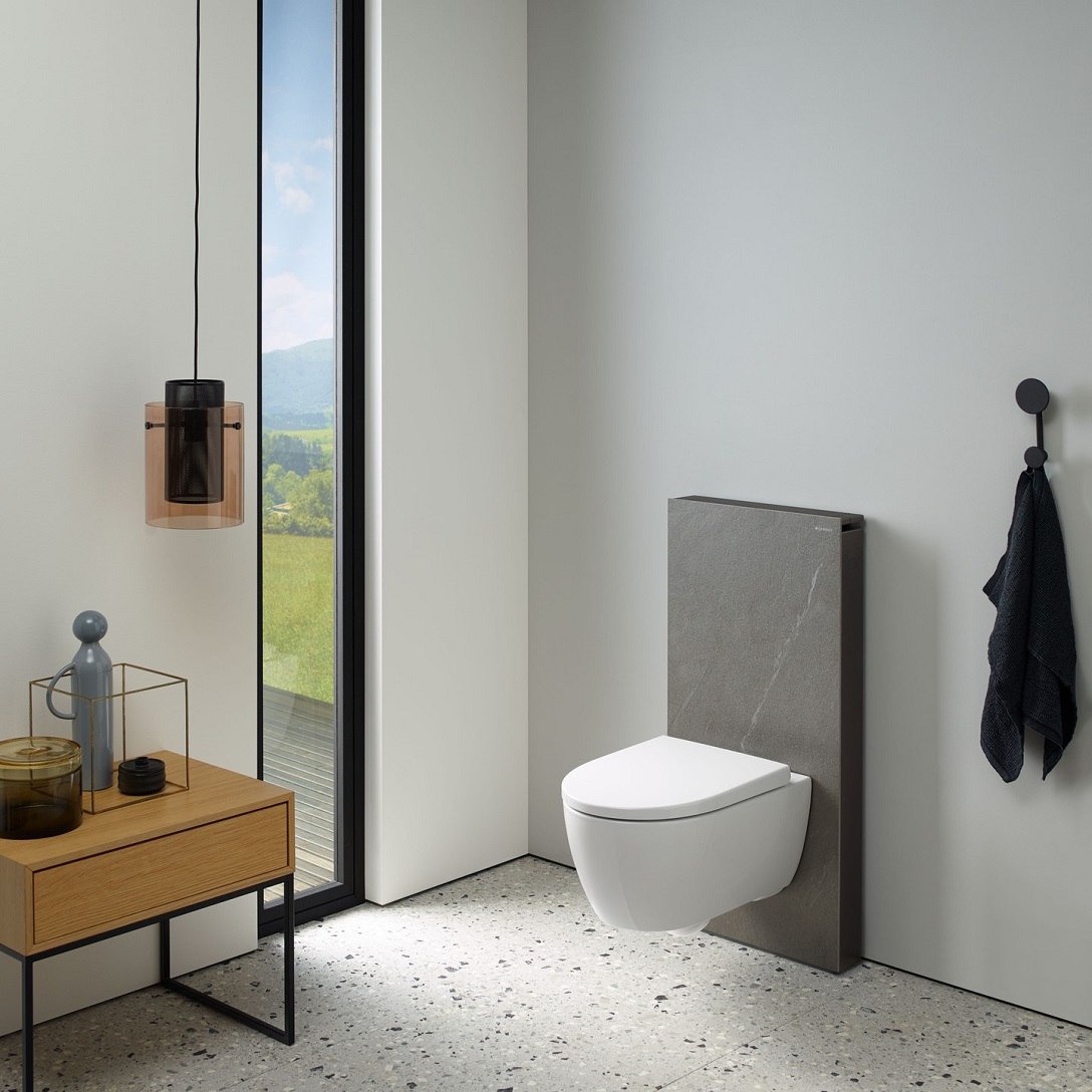 toilet with slate look backing in a bathroom with wodden furniture and a view to the outdoors
