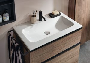 Wooden surfaces and finishes by Geberit in the bathroom with a square basin and black taps