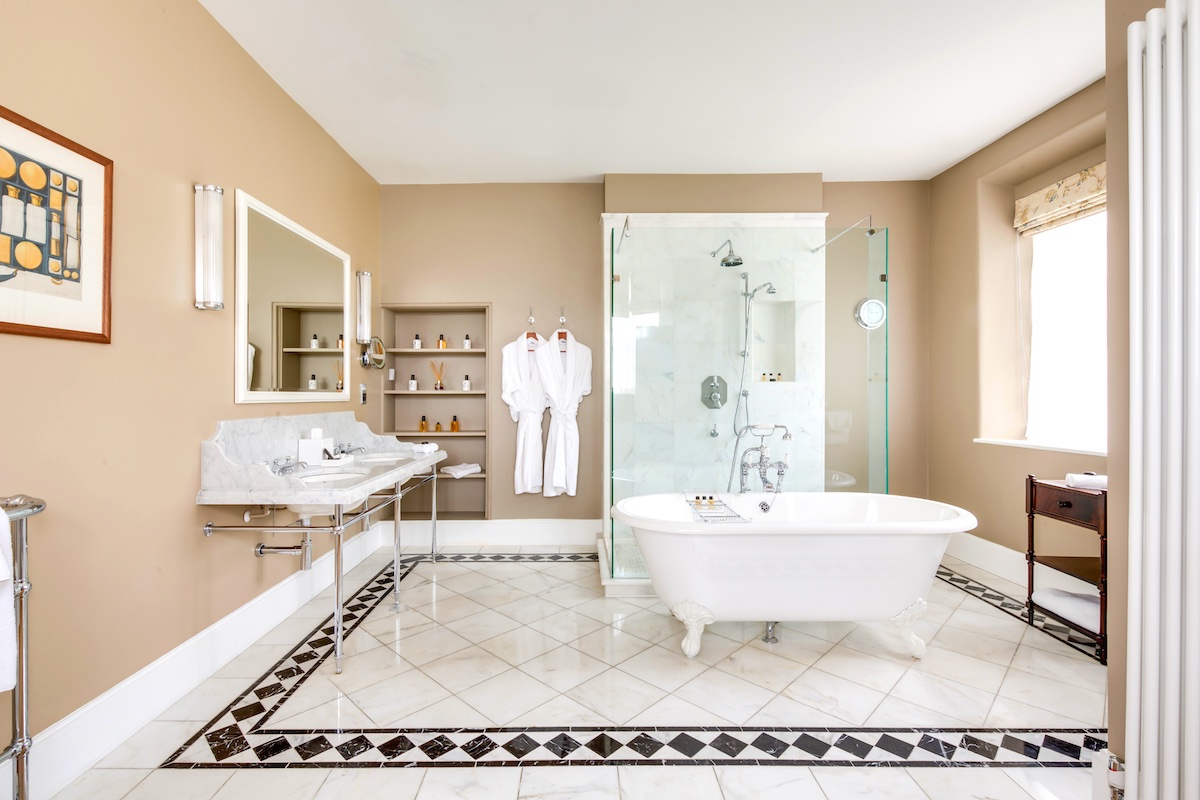 A large, open and traditional yet modern bathroom with freestanding tub and glass shower unit