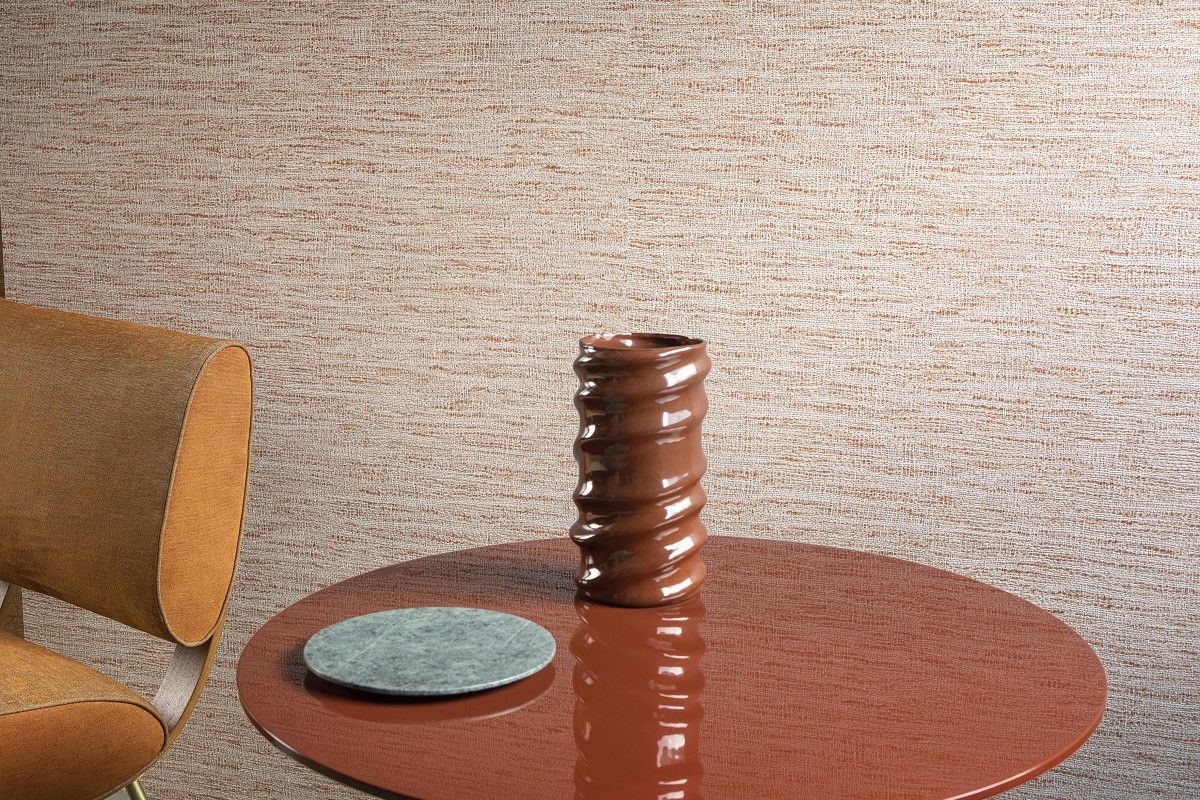 brown chair and table with a brown sculptural vase against textured brown arte wallcovering