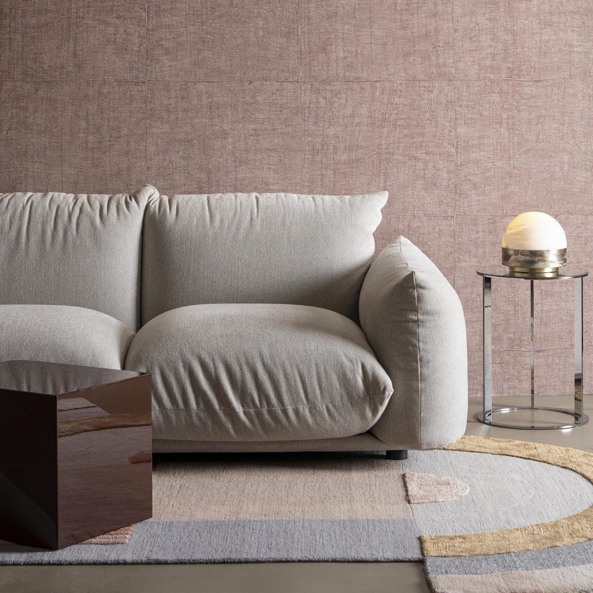 cream couch on abstract patterned carpet with textured Arte wallcovering behind