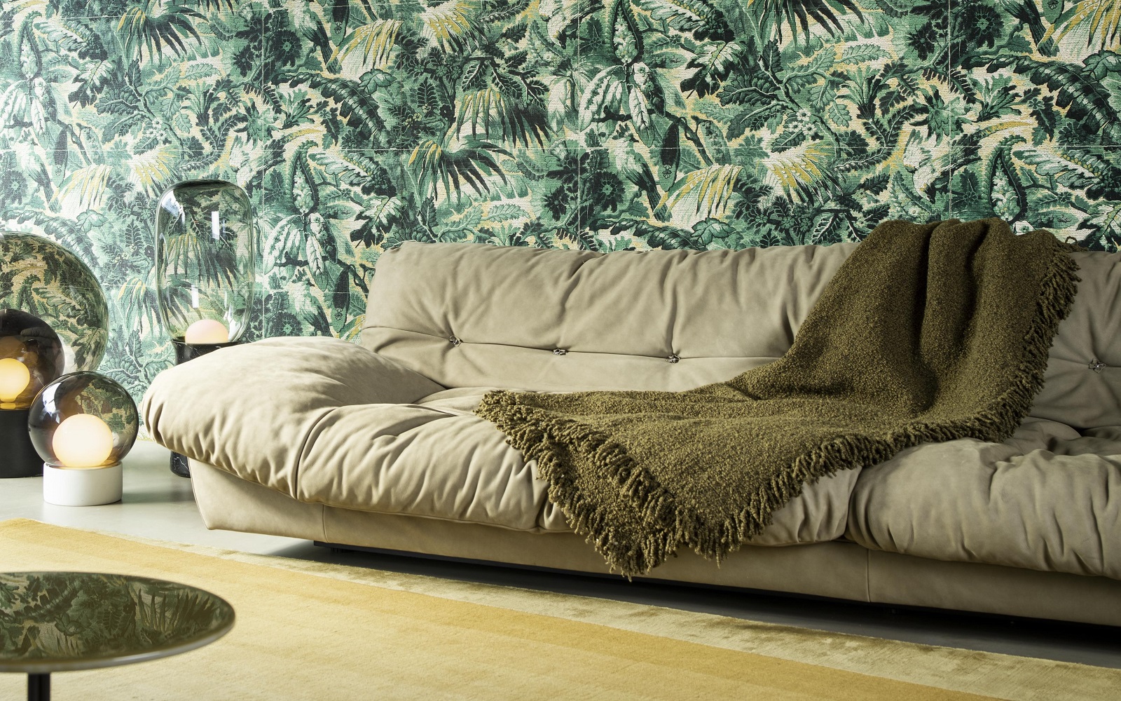 cream puffy couch with green woven throw in front of textured green anitgua Tropicali wall covering by Arte