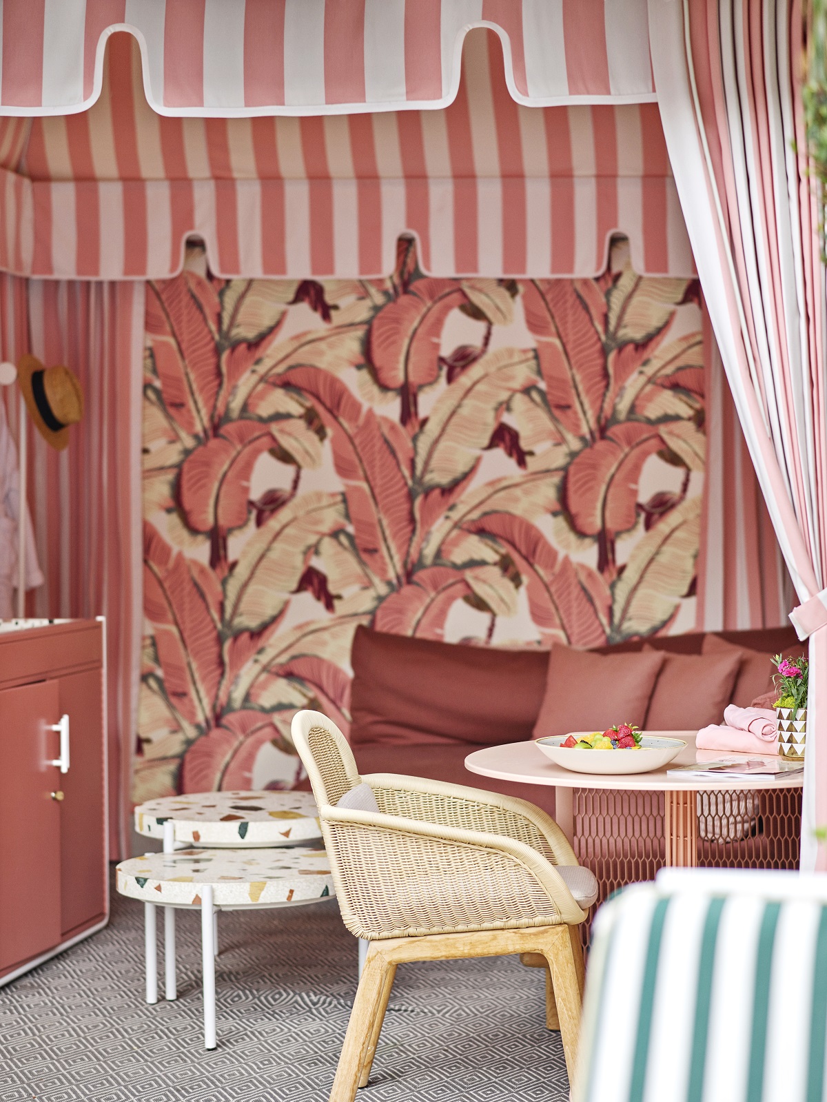 pink banana leaf wallpaper and green striped chairs in the cabana at Beverley Hills Hotel by Champalimaud Designs