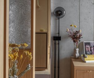 yellow dried flowers in front of glass and wood panels layered through the guestroom at Locke Berlin