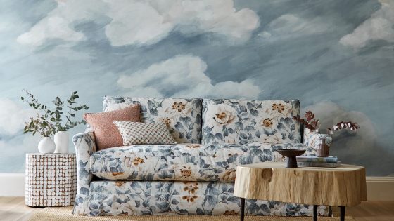 upholstered couch in Harlequin colour 4 fabric in front of wall painted with cloud mural