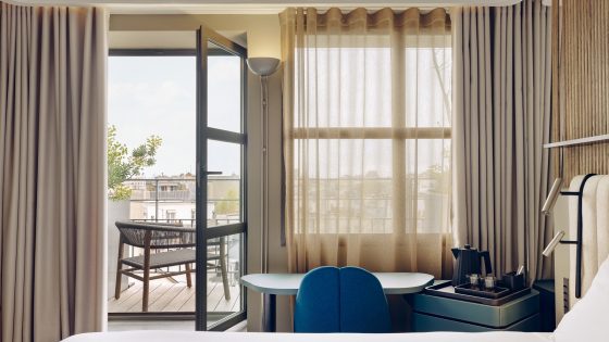 guestroom in Hôtel Dame des Arts with glass door opening onto terrace and views over Paris
