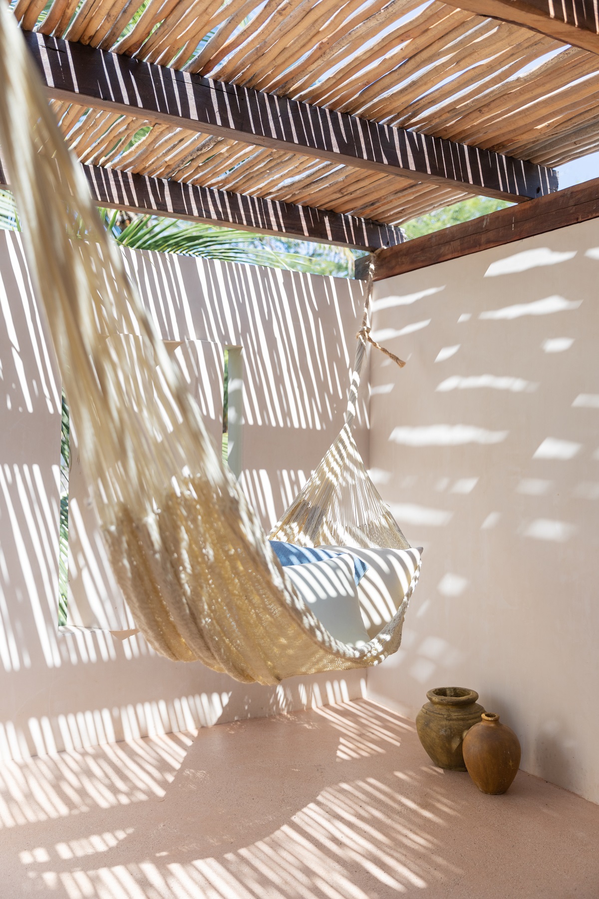 Hammock under bamboo roof with dappled light