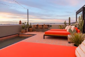 red sunloungers and cacti on the rooftop of Los Hoyos