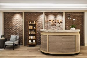 desk and display area in wood, stone and natural colours on surfaces and design of Mokara spa