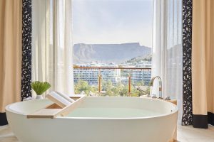 freestanding bath with bookstand in guestroom of One&Only Cape Town with vies of Table Mountain
